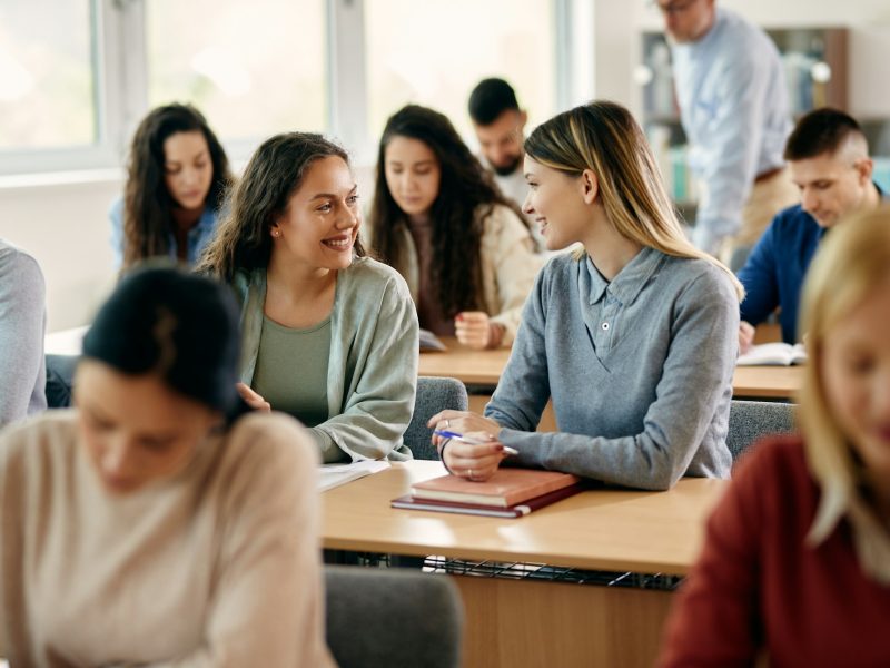 Happy female students talking during a class at the university.